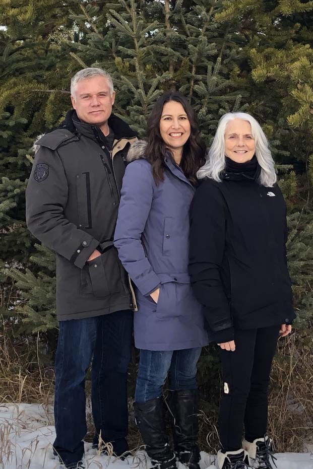 3 person standing in front of a pine tree