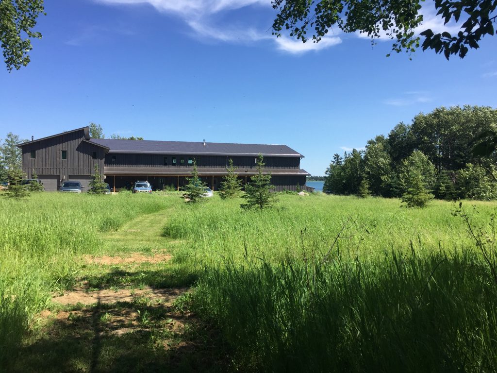 Brown two storey building with green grass in front