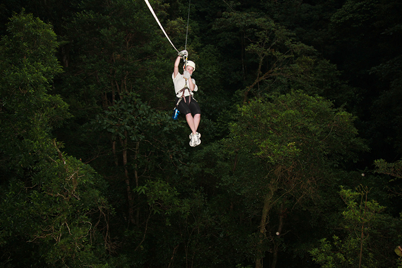 Women is ziplining in the rainforest