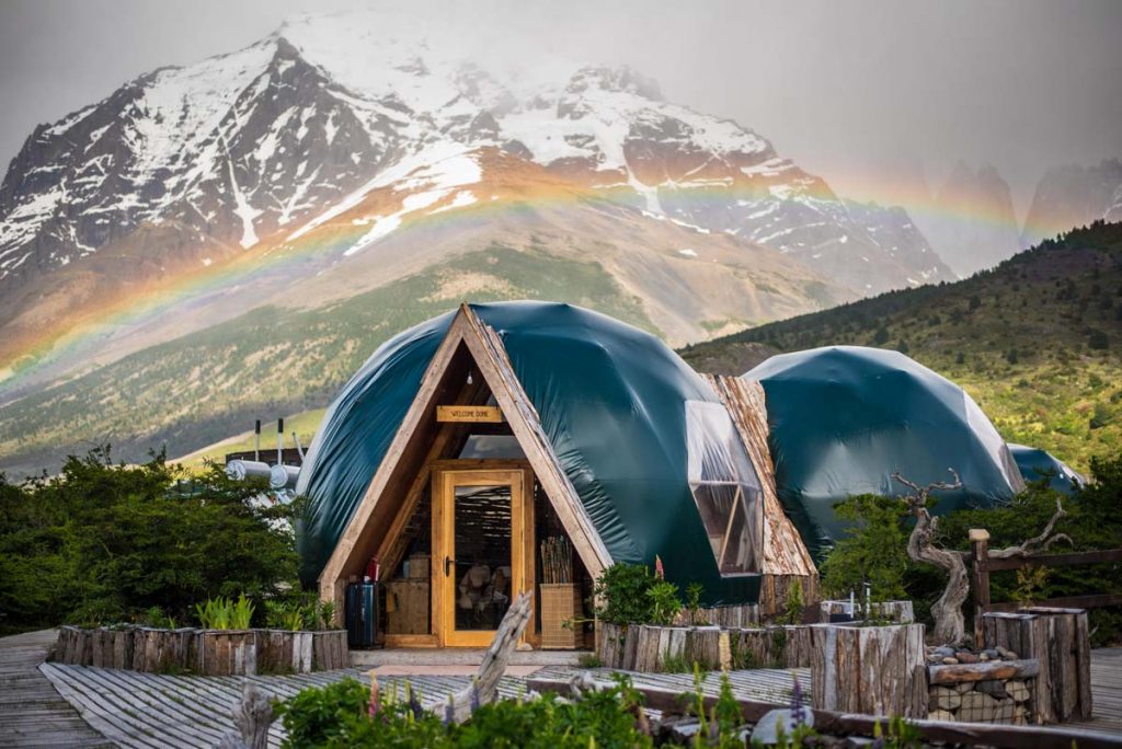 Dome-shaped glamping tents in front of snowy mountains