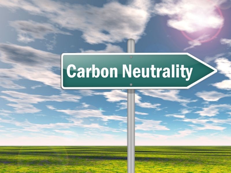 A green arrow sign with an overlay text saying carbon neutrality