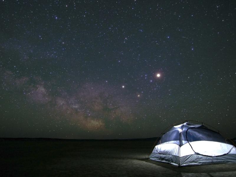 A tent in the dark with stars above