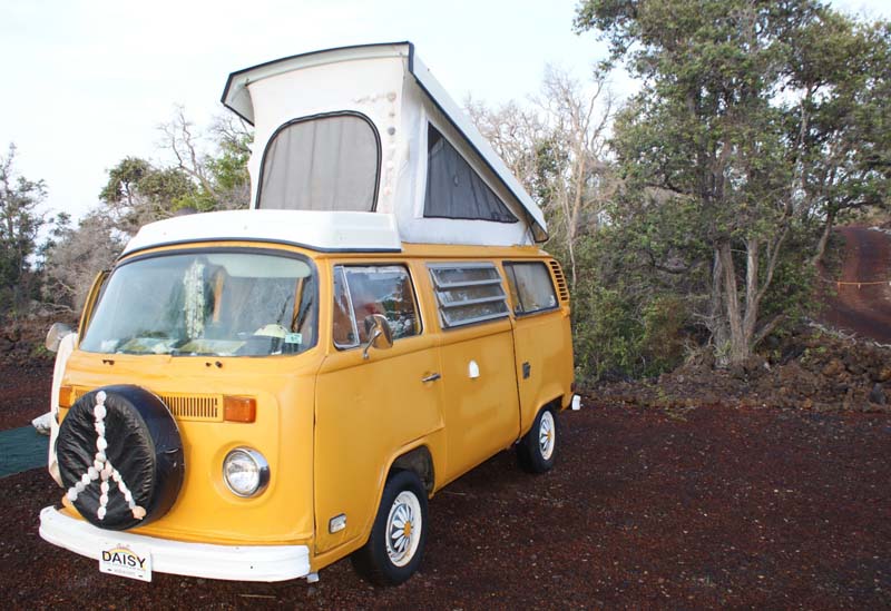 Yellow camper with a small white tent on the top. 