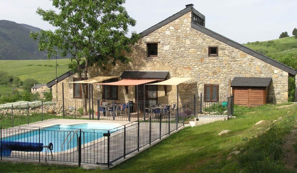 A lodge house with a swimming pool in front.