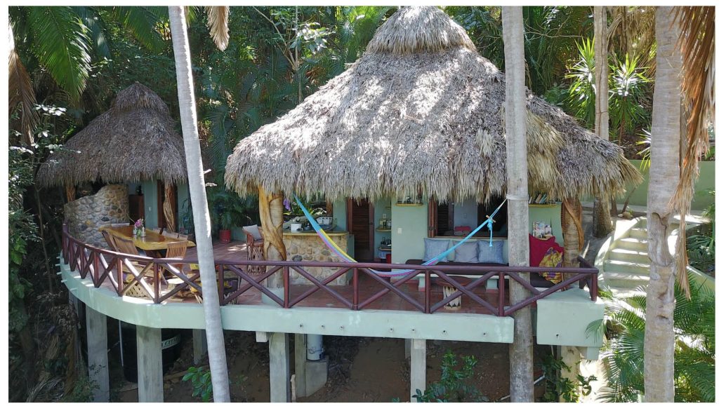 A tree house with straw bale rood and large terrace. 