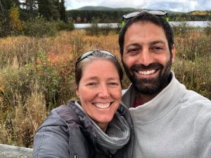 A woman and a man smiling in from a lake and wetlands. 