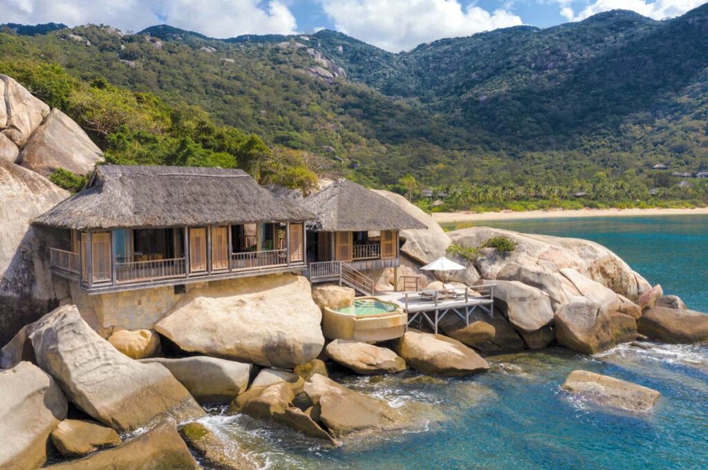 Small cottage with straw bale roof on the rocks by the sea.