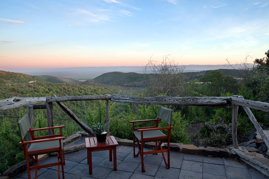 A balcony with chairs and a view to the mountains. 