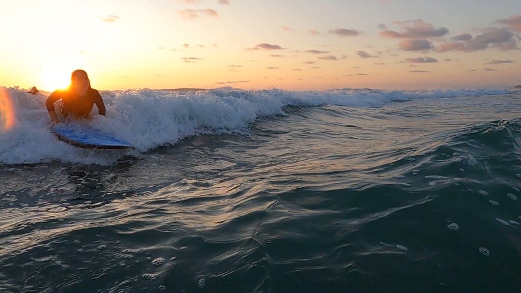 A woman is surfing a small wave