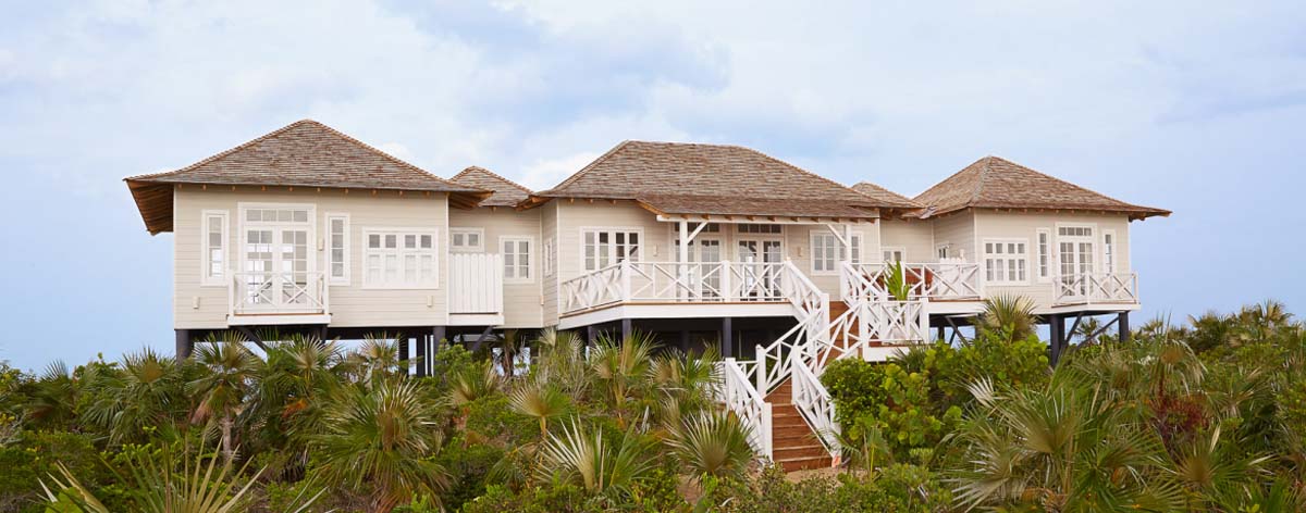 White wooden house on stilts on top of a hill