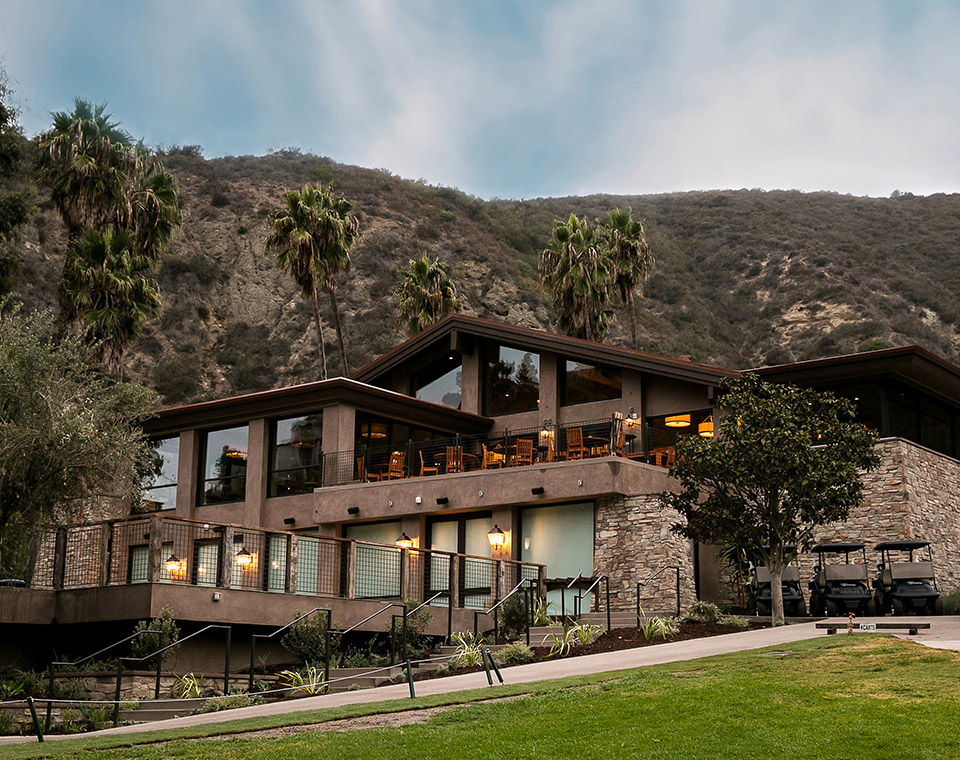 A wood and stone building in front of a mountain