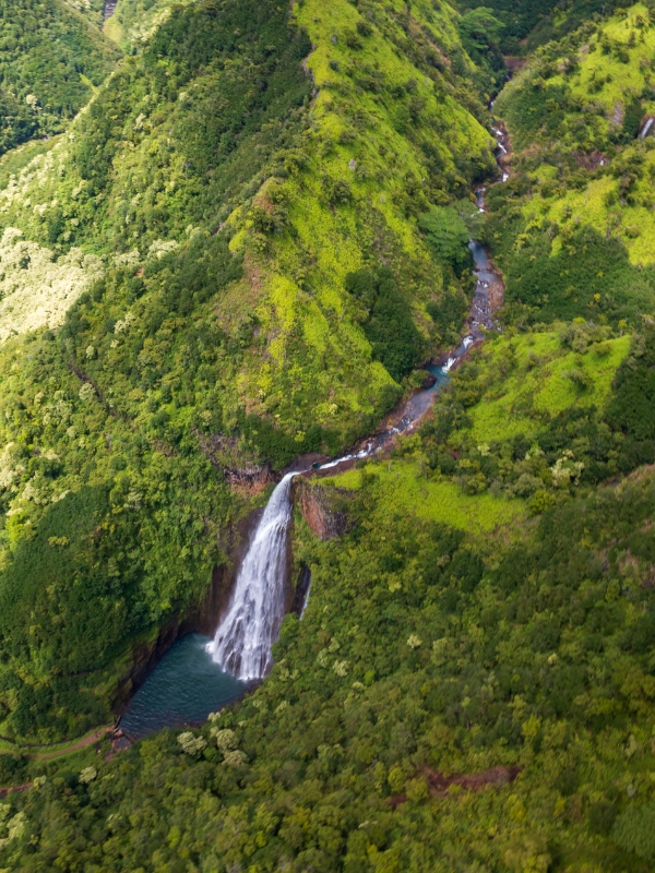 Aerial view of a large waterfall in green lush jungle