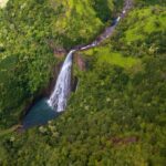 Aerial view of a large waterfall in green lush jungle