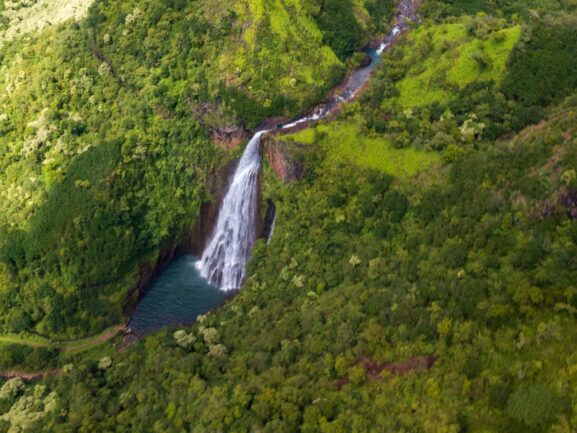 Aerial view of a large waterfall in green lush jungle