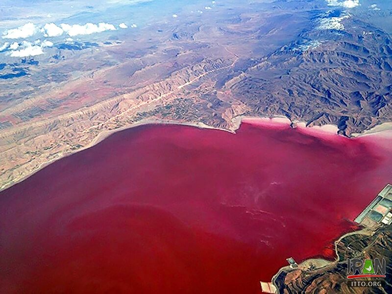 Vibrant pink lak surrounded by rocky terrain. 