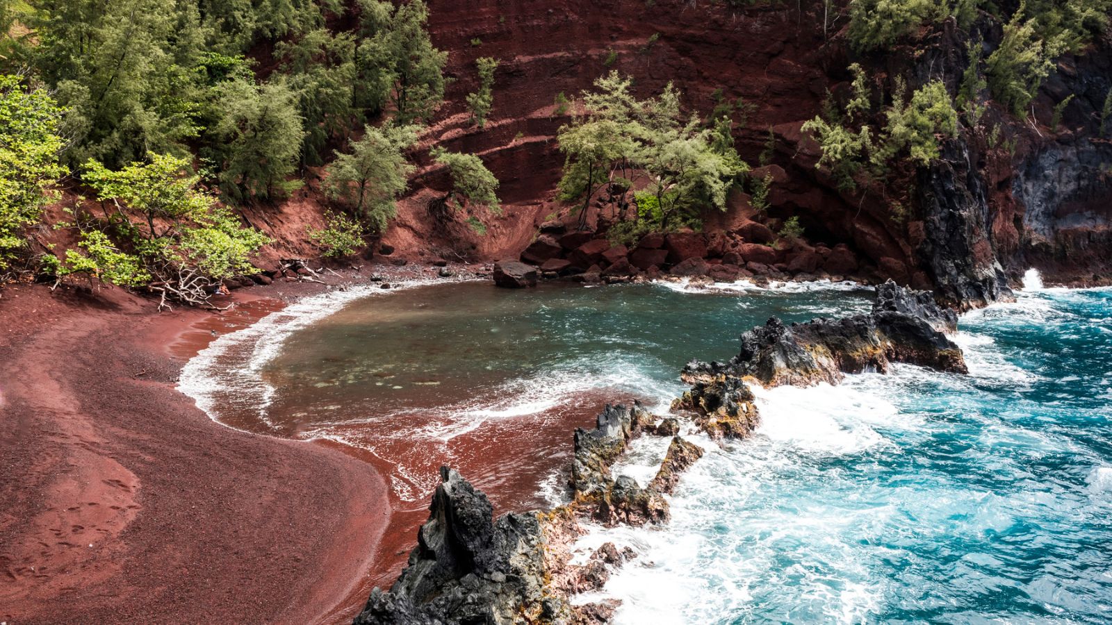 red sand beach with huge red cliffs
