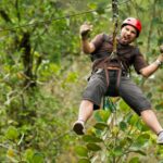 Ziplining male brown clothes red helmet