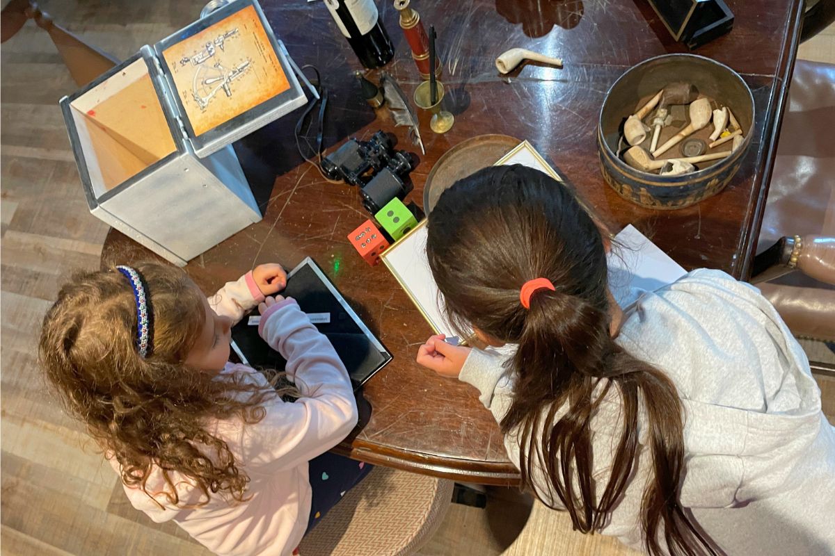 Two kids are busy solving puzzles and codes in an escape room.